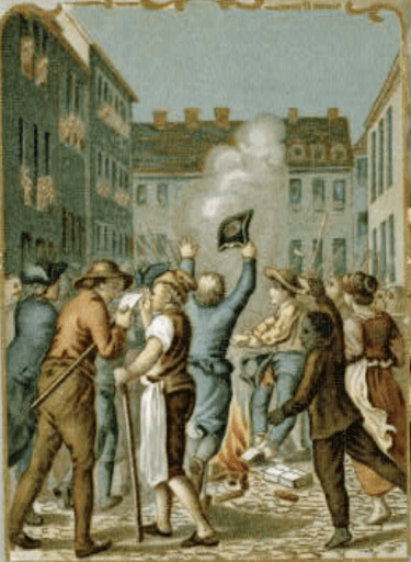 A vintage illustration depicts a group of colonists rioting in a cobblestone street in a city. One man raises his hat in the air, and a small fire or smoke rises from the ground, with fallen boxes and papers scattered nearby.