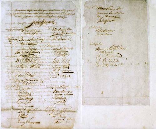 An image of a scanned copy of the handwritten pages of the Olive Branch Petition. The document is covered with many large, elegant signatures from colonial representatives, with some body text visible at the top.