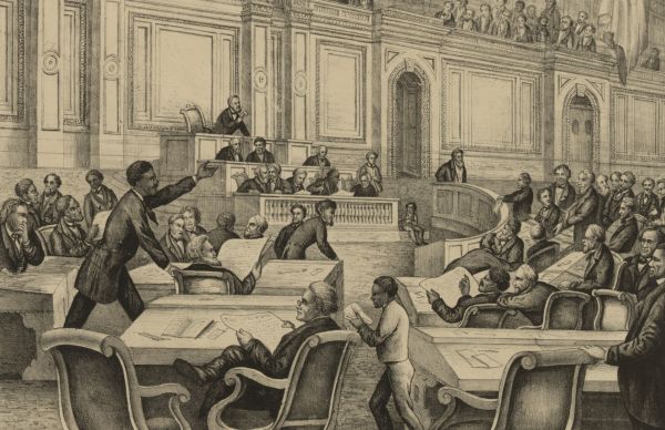 Congressman Robert Brown Elliott, a Black man wearing a suit, stands at a desk in a crowded legislative chamber, gesturing with one hand as he addresses a group of seated and standing men. The historic engraving shows a busy scene on the House floor with individuals reading papers, listening intently, and a young page walking through the desks.