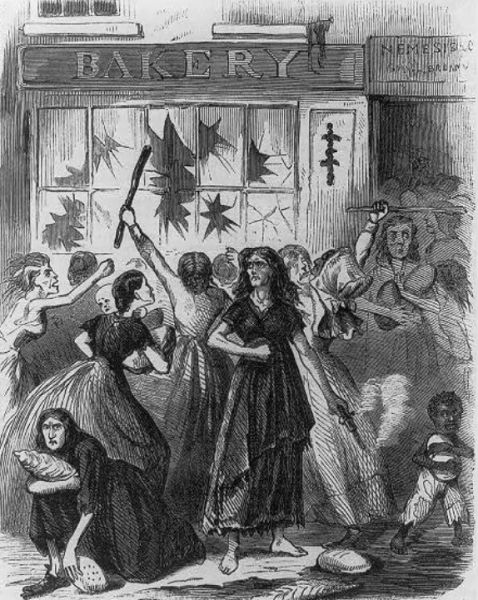 An engraving shows a group of women rioting in front of a bakery with shattered windows. Several women are seen carrying loaves of bread or brandishing clubs, while one woman in the center holds a pistol.