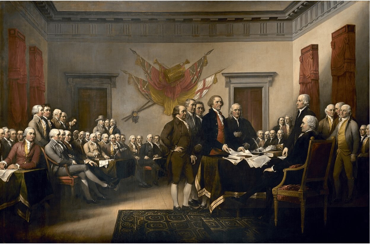 A famous painting shows a large group of men gathered in a formal room with a table and chairs. A small group of men stands at the center table, presenting a document to others who are seated around the room.