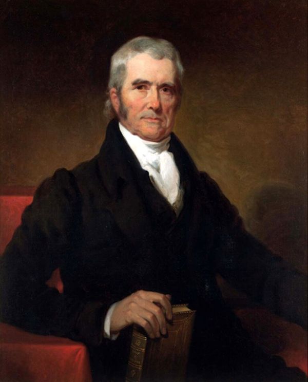 A three-quarter-length portrait shows Chief Justice John Marshall, a man with graying hair, seated in a red armchair and holding a book, with a serious expression. He is dressed in a dark suit with a high white cravat, his posture formal and commanding.
