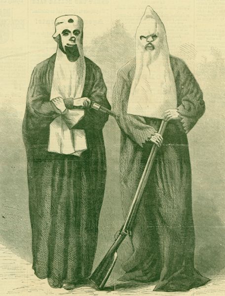 An illustration depicts two Ku Klux Klan members wearing long, dark robes and tall, pointed white hoods that cover their faces except for small eye holes. One member holds a pistol across their chest, while the other stands with both hands resting on the barrel of a long rifle.