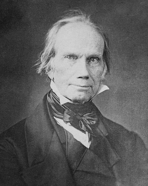 A black-and-white photograph shows a serious-looking Henry Clay, with his hair disheveled and a calm expression on his face. He is wearing a dark suit with a bow tie and a high-collared shirt, and the image captures the weariness of a long political career.