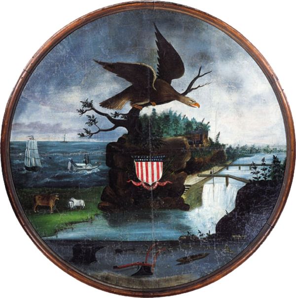 A folk art painting in a circular frame depicts a large bald eagle perched on a rock formation at the center of a diverse landscape, with a shield displaying the American flag below it. The scene features various elements of American life, including a steamboat on the ocean, a farm with a cow and a horse, a waterfall, and agricultural tools like a plow.