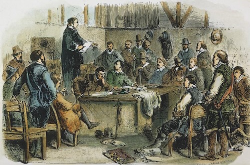 A colored historical illustration depicts the First General Assembly of Jamestown in 1619, showing a group of 17th-century European men convened for a colonial meeting. At the far left, a man holding a document stands to address the assembly, while elected burgesses and officials sit around a central table listening and taking notes.
