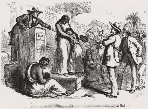 This is a somber black-and-white illustration depicting an enslaved family being sold at auction, with a white auctioneer standing on a box next to a distressed enslaved woman holding and comforting her child on the auction block. Surrounding them are several white men examining the people for sale, highlighting the brutal and dehumanizing nature of the slave trade.