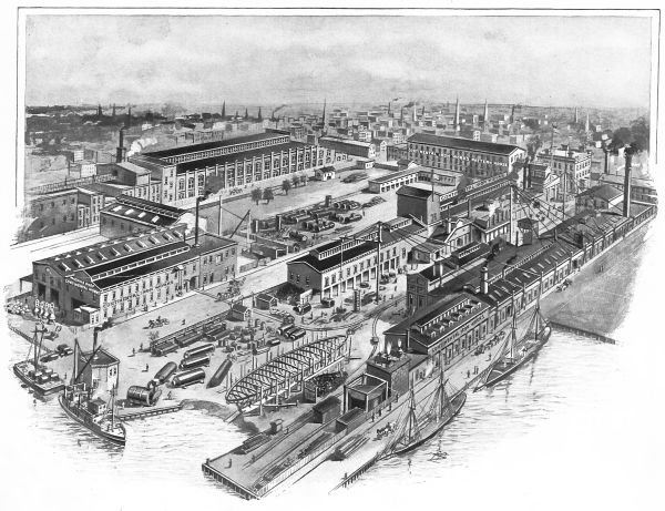 This black-and-white aerial illustration shows the sprawling Iron Works complex located along a busy waterfront. Several large industrial buildings and machine shops are surrounded by courtyards filled with equipment, while multiple masted ships and a partially constructed vessel are docked at the piers in the foreground.