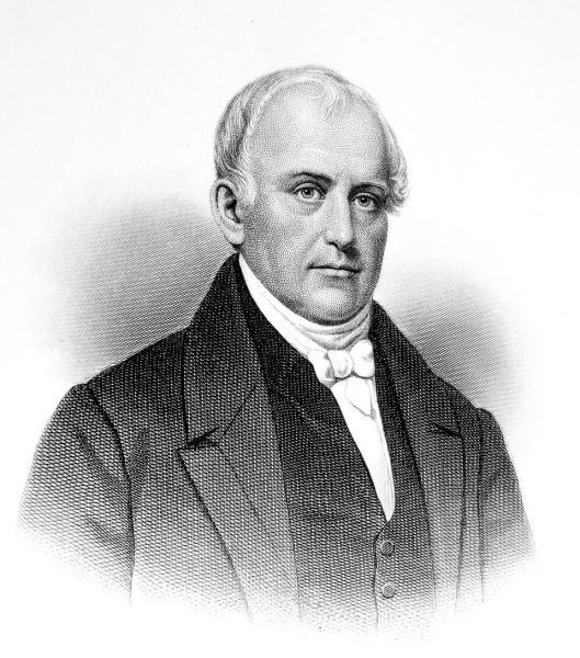 A black and white portrait engraving depicts a middle-aged man with short, thinning hair, facing forward with a serious expression. He wears formal attire, including a dark jacket, a vest, a high white shirt collar, and a white cravat tied in a bow.